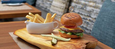 Una mesa de madera con una hamburguesa y papas fritas.