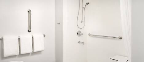 A modern bathroom with a shower, toilet, and grab bars.