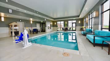 Una piscina techada, sillones reclinables de piscina