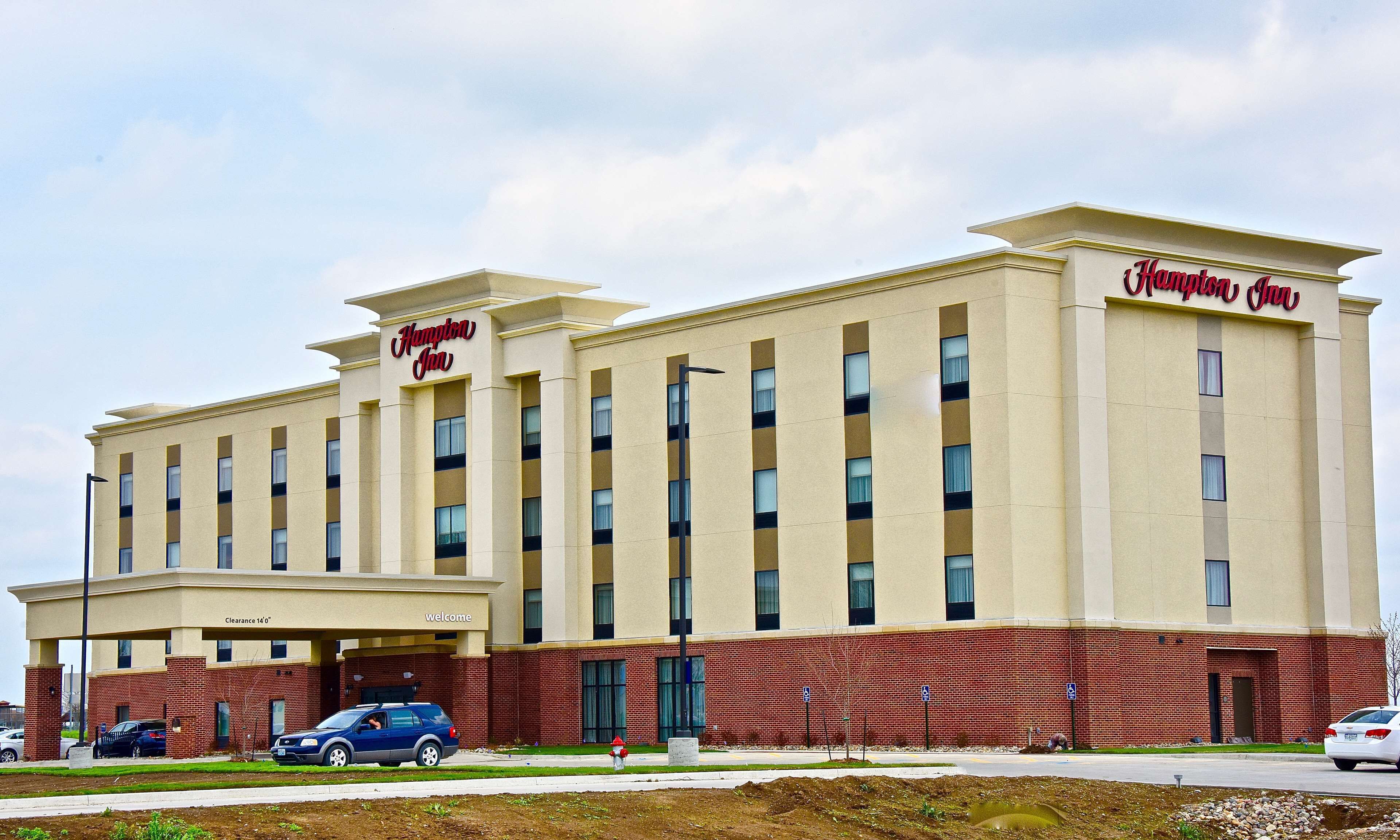 A large, multi-story hotel with a prominent "Hampton Inn" sign.