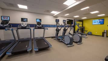 A gym with treadmills, elliptical machines, and a stationary bike.