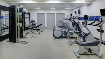 A gym with various exercise machines, including treadmills and a weight machine.