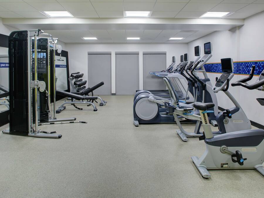 A gym with various exercise machines, including treadmills and a weight machine.