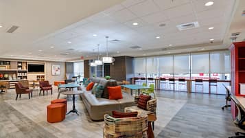 A spacious lounge area with a sofa, chairs, and a dining table.