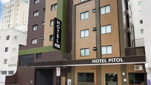 Een meerlaags hotel met een bord waarop 'HOTEL PITOL' staat.