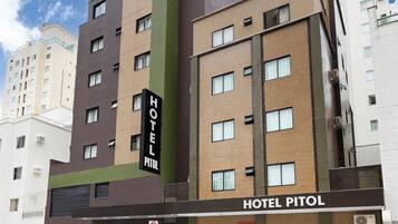 Un hotel de varios pisos con un letrero que dice 'HOTEL PITOL'.