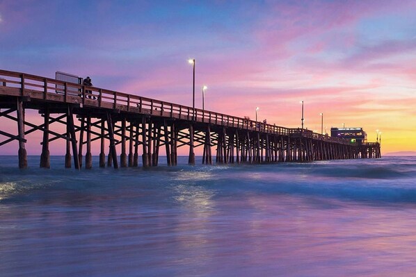 A pier extending into the water with a wooden walkway and railings.