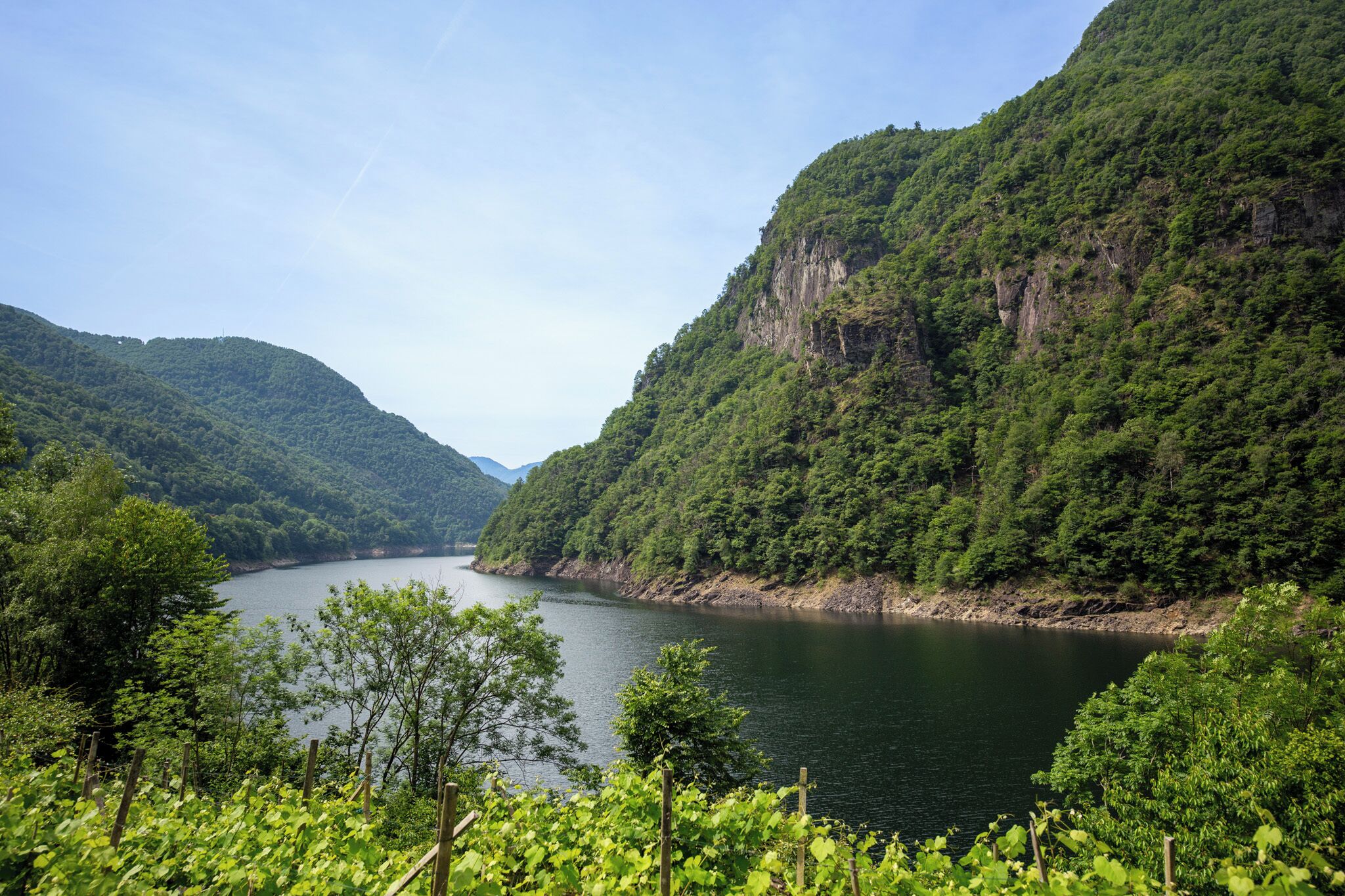 A serene lake surrounded by lush green hills.