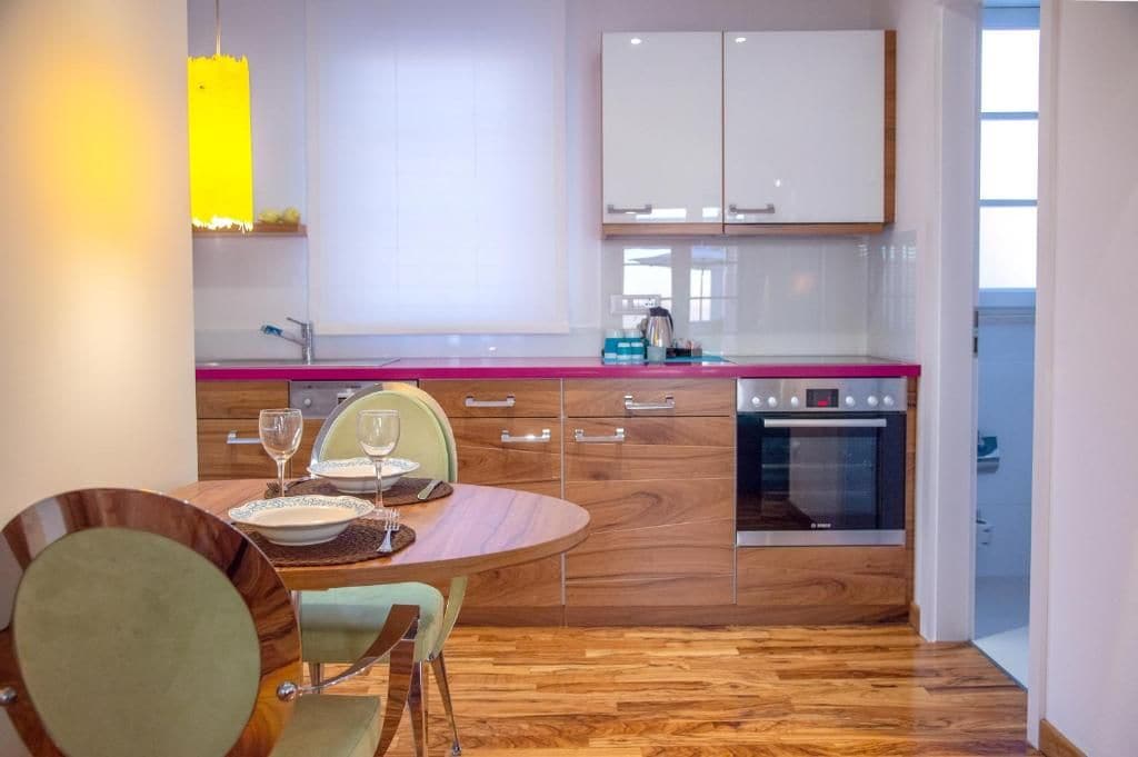 Una cucina moderna con tavolo, sedie e forno a incasso.