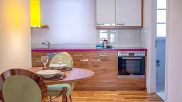 Una cucina moderna con tavolo, sedie e forno a incasso.