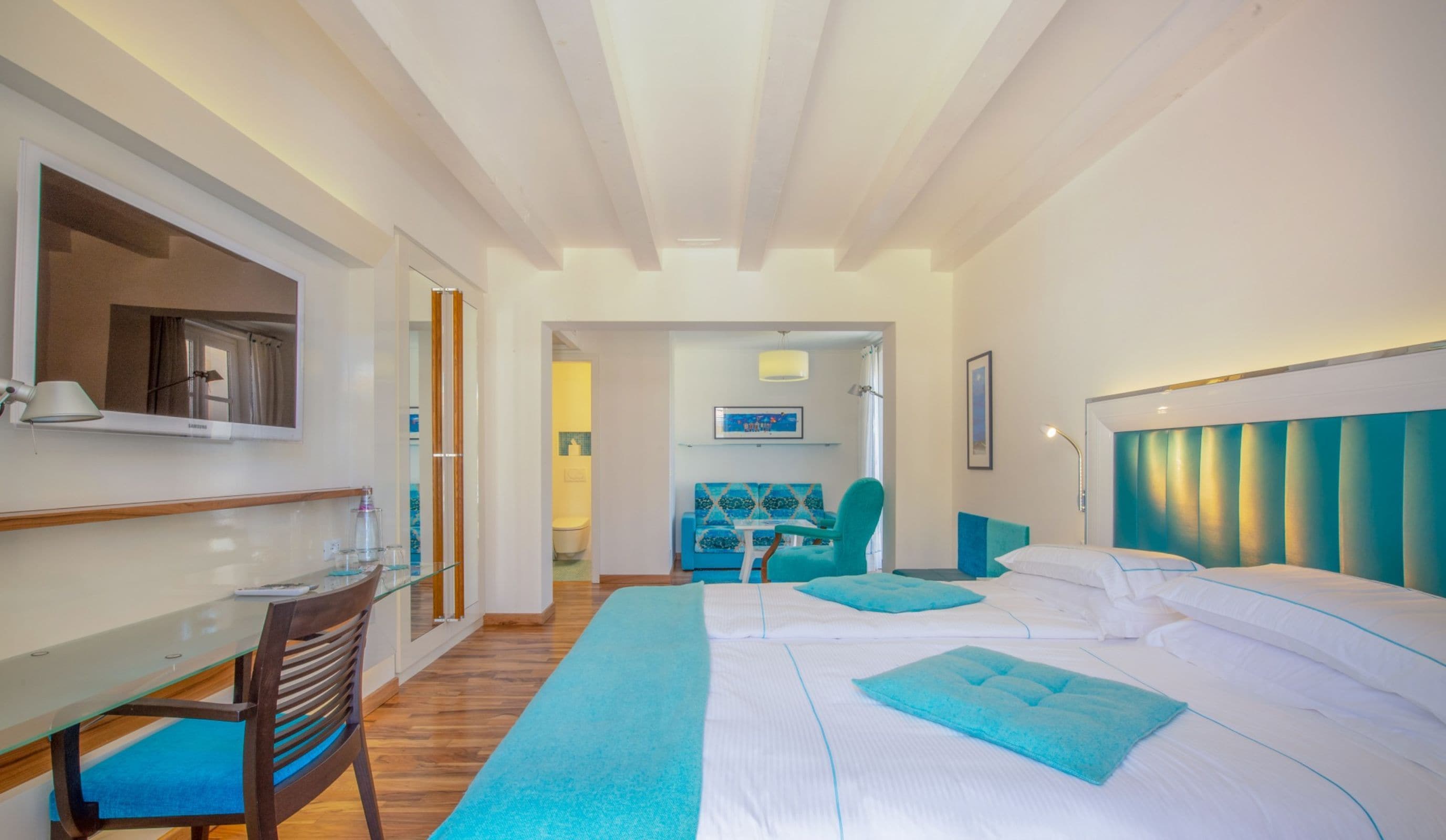 Una camera d'albergo con un letto, una scrivania, una sedia e un divano.