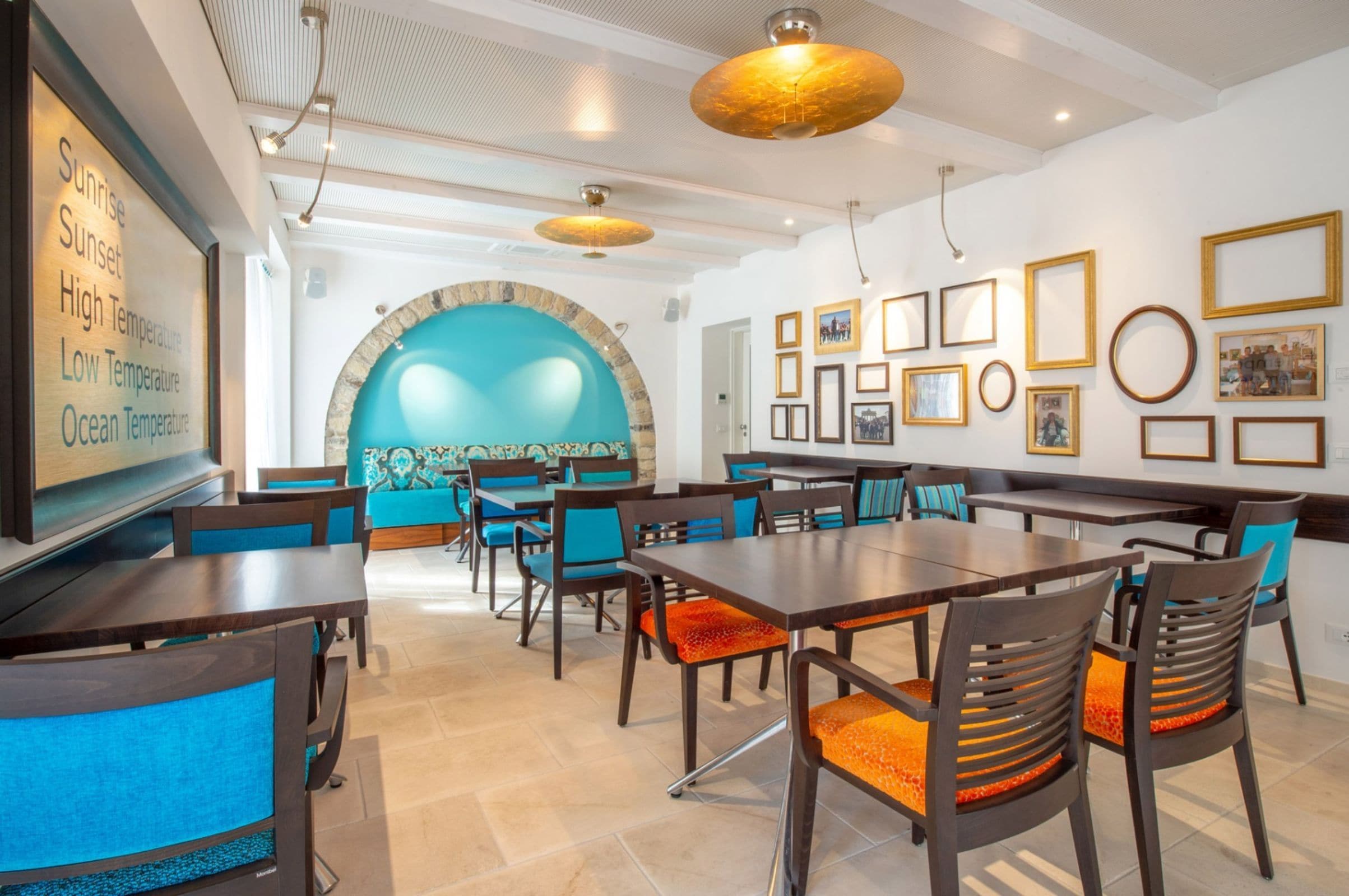 A restaurant with a large wall mural, multiple dining tables, and chairs.