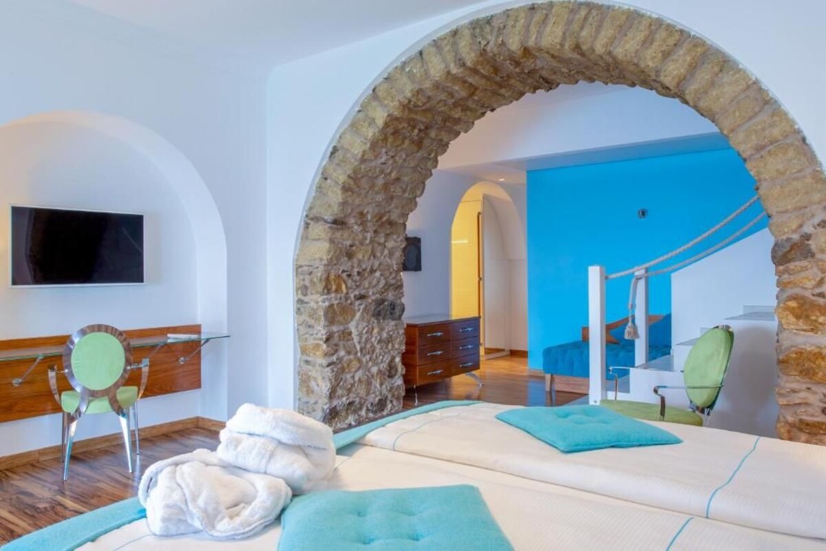 A room with a stone arch, a massage table, a TV, and a blue wall.