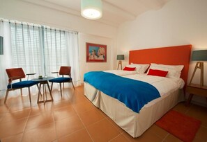 A hotel room with a bed, two chairs, a table, a painting, and a lamp. - Piccolo Grand Hotel (Pizzo)