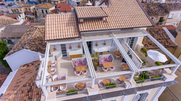 A rooftop terrace with outdoor seating and a view of the surrounding neighborhood. - Piccolo Grand Hotel (Pizzo)