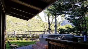 An outdoor patio with a wooden deck, a barbecue grill, and a table. - The Perfect Sun Valley Vacation Home (Sun Valley)