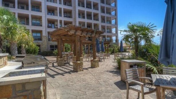Un cortile con posti a sedere all'aperto, una pergola e una zona piscina.