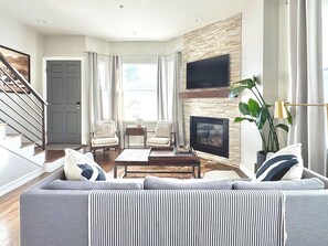 Smart TV, chimenea, libros y biblioteca musical 