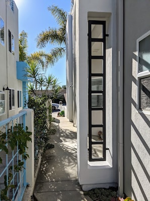 Stroll along the pathway to an entrance, surrounded by modern buildings and lush greenery.