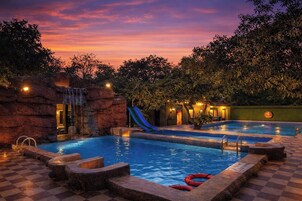 Una piscina al aire libre, sombrillas, tumbonas