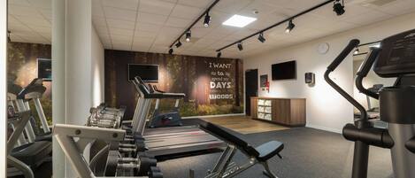 A gym with treadmills, dumbbells, and weight machines.
