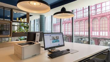 A modern office desk with a desktop computer, printer, and keyboard.