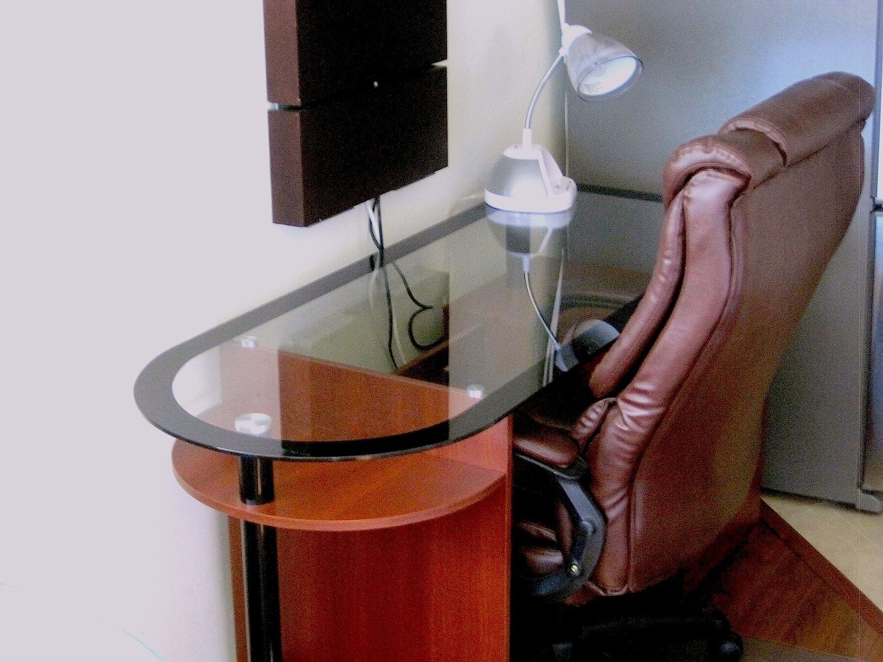 Een draaistoel met een bureau en een lamp.
