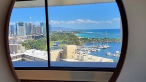 A round window with a view of a marina, buildings, and a clear sky. - Absolutely Ocean View  - Great Location - Legal - Free Parking (honolulu)