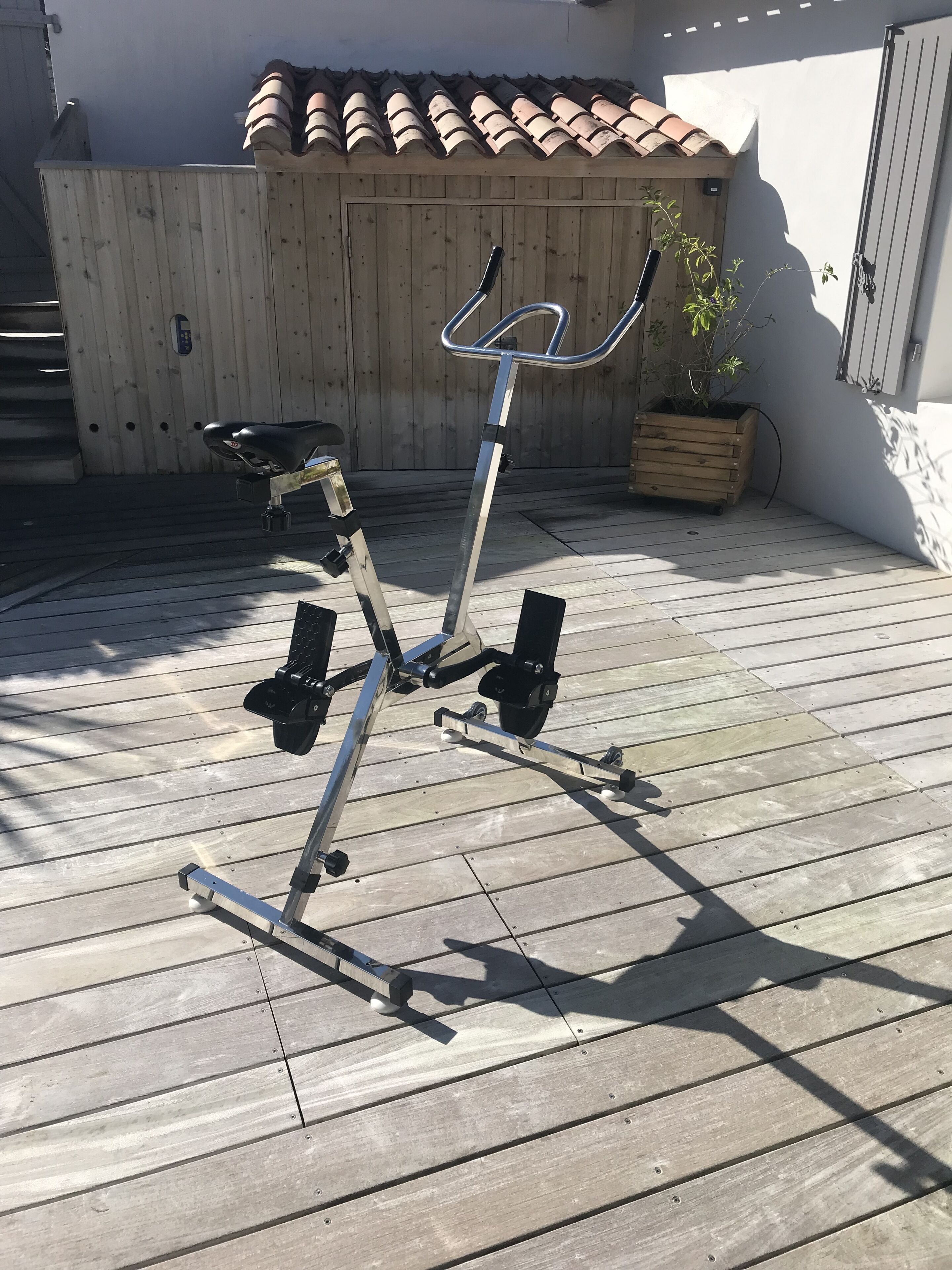 An outdoor exercise machine on a wooden deck.