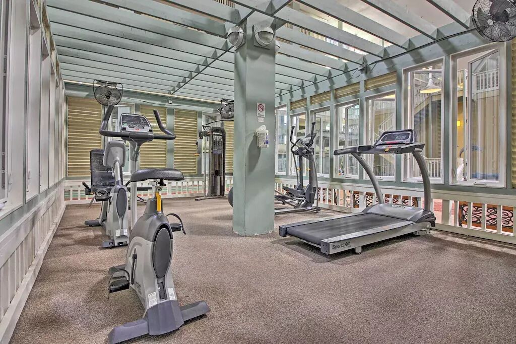 A gym with stationary bikes, treadmills, and a weight machine.