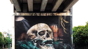 Un murale raffigurante un teschio su una struttura in cemento sotto un ponte.