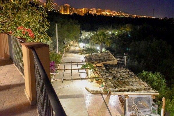 Een balkon met uitzicht op een verlichte stad.