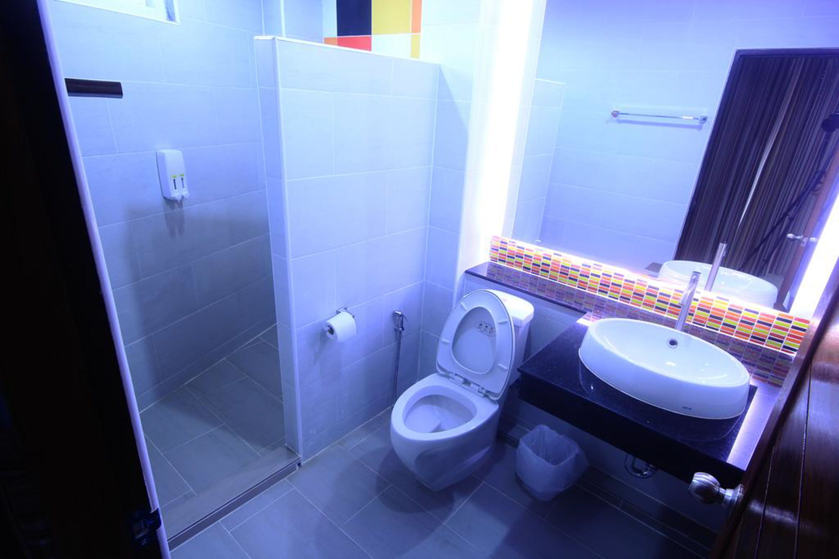 A modern bathroom with a toilet, sink, and glass shower enclosure.