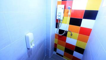 A bathroom with a shower, a soap dispenser, and a colorful tiled wall.