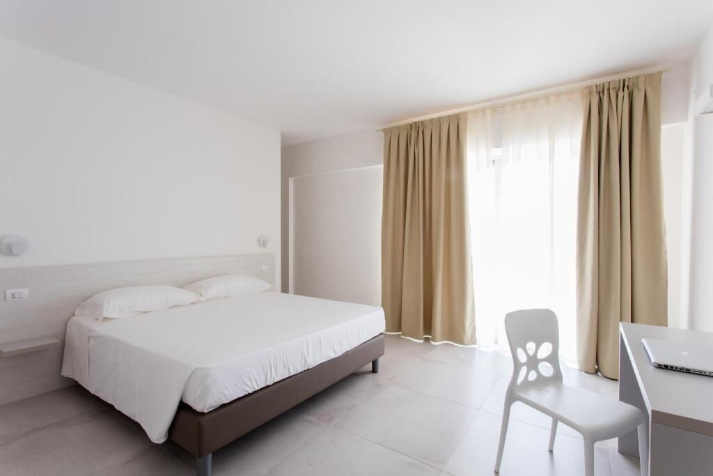 Una habitación de hotel moderna con una cama, un escritorio y una silla.