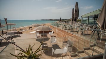 Ranta lähistöllä, valkoista hiekkaa, aurinkotuoleja, aurinkovarjoja