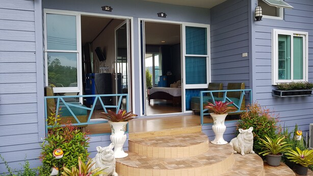 A house with a covered porch, a staircase leading to the entrance, and a number '10' sign above the door. - Baanmorkburi Resort (Khao Kho)
