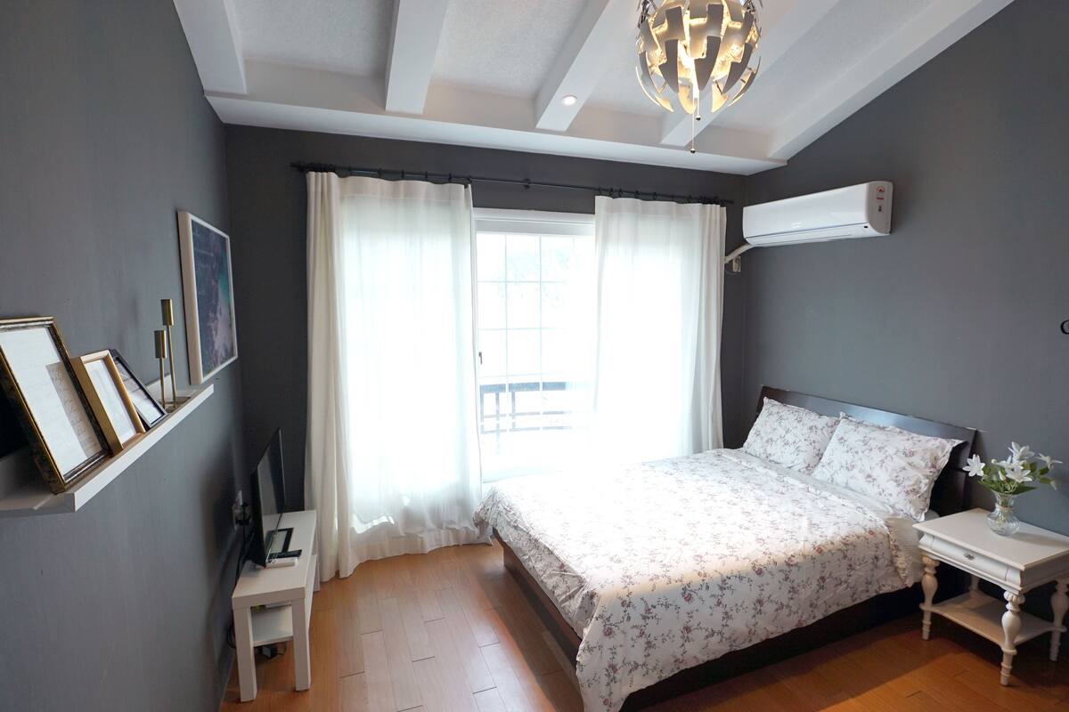 Ein Schlafzimmer mit einem Bett, einem Nachttisch und einer Deckenleuchte.