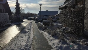 A snow-covered residential street with houses on both sides, a clear sky, and a visible street lamp. - Nice and quiet apartment in Markdorf am Gehrenberg with the Walther family (Markdorf)