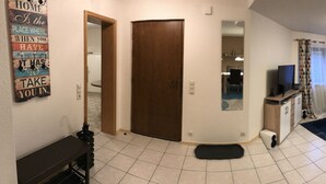 A spacious living room with a sofa, coffee table, and a TV. There is a dining area with a table and chairs. The room has a large window with curtains. - Nice and quiet apartment in Markdorf am Gehrenberg with the Walther family (Markdorf)