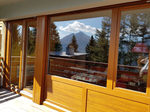A wooden-framed window with a view of a mountain and trees. - Spacious F3 South facing, Resort Center, Quiet, Terrace and Covered Parking  (Orcières)