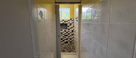 A narrow hallway with tiled walls and a checkered floor pattern.