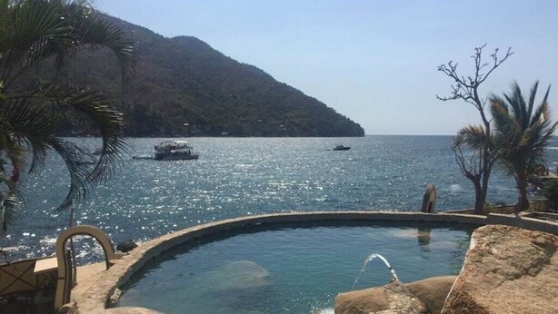 A pool with a view of the sea and a mountain in the background. - VILLA MARINA - Spectacular Designer Remodel with Mountain & Marina Water Views (Puerto Vallarta)