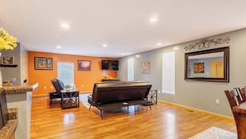 A spacious living area with hardwood flooring, a dining table, and a sofa.