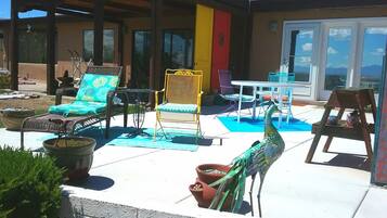 An outdoor patio with various seating options, including wicker chairs and a table.