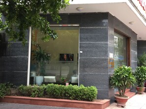 A building entrance with a glass door, potted plants, and a security camera. - Thai Hoa Hotel (Hanoi)