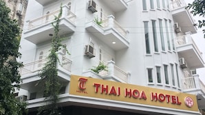 A multi-story building with a sign for Thai Hoa Hotel. The building has multiple balconies with air conditioning units. - Thai Hoa Hotel (Hanoi)