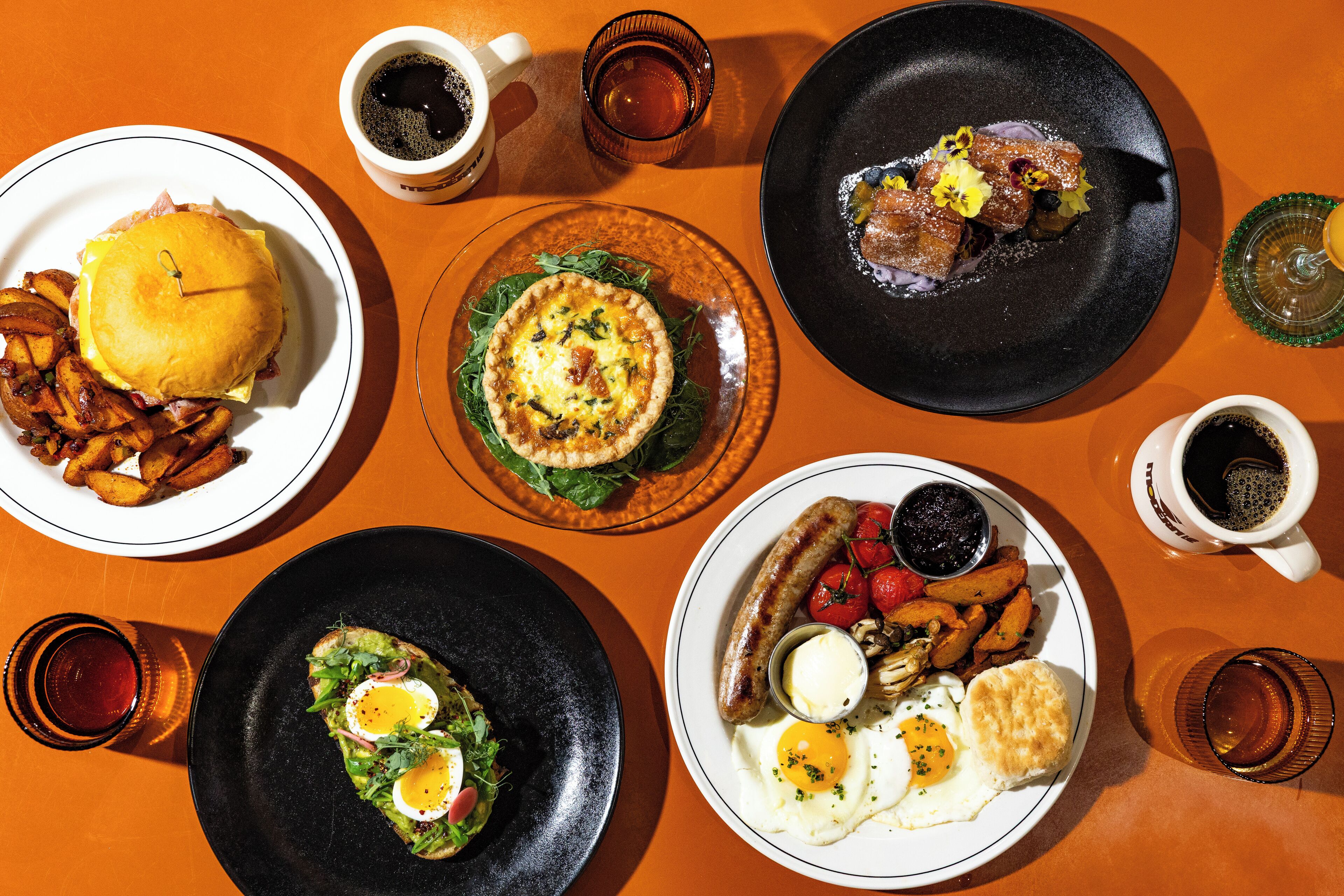 A table with various breakfast dishes including eggs, bacon, and pancakes.