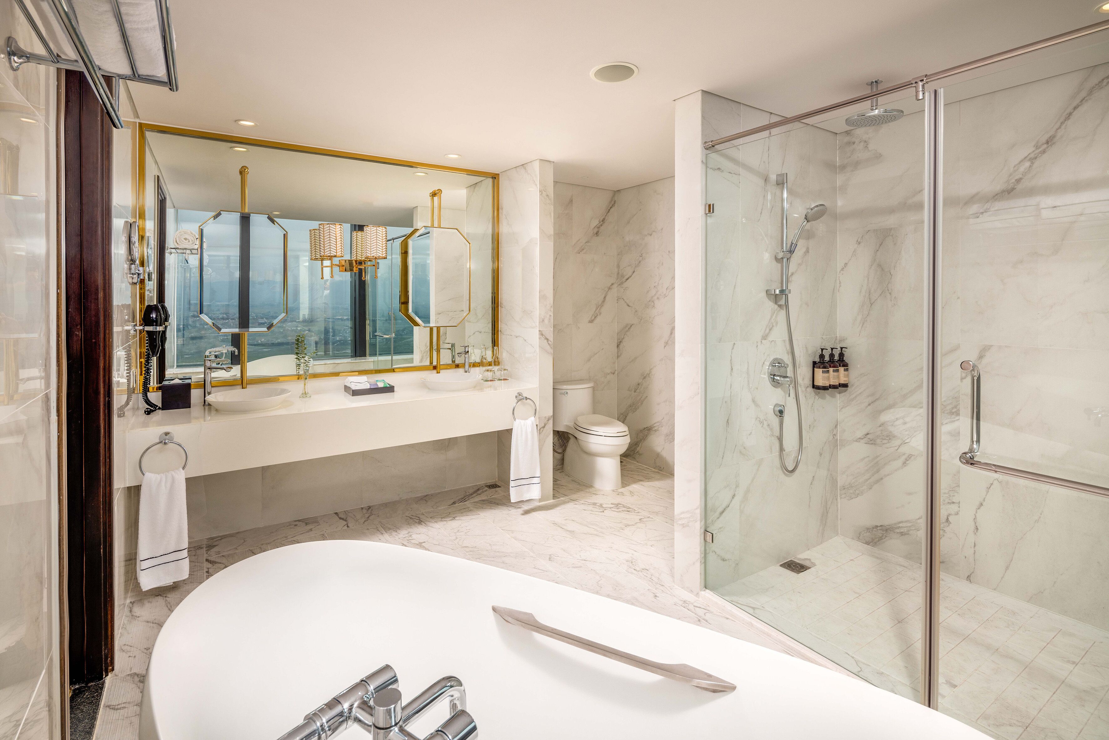 Ein modernes Badezimmer mit einer großen Badewanne, einer Duschkabine und einem Marmorboden.