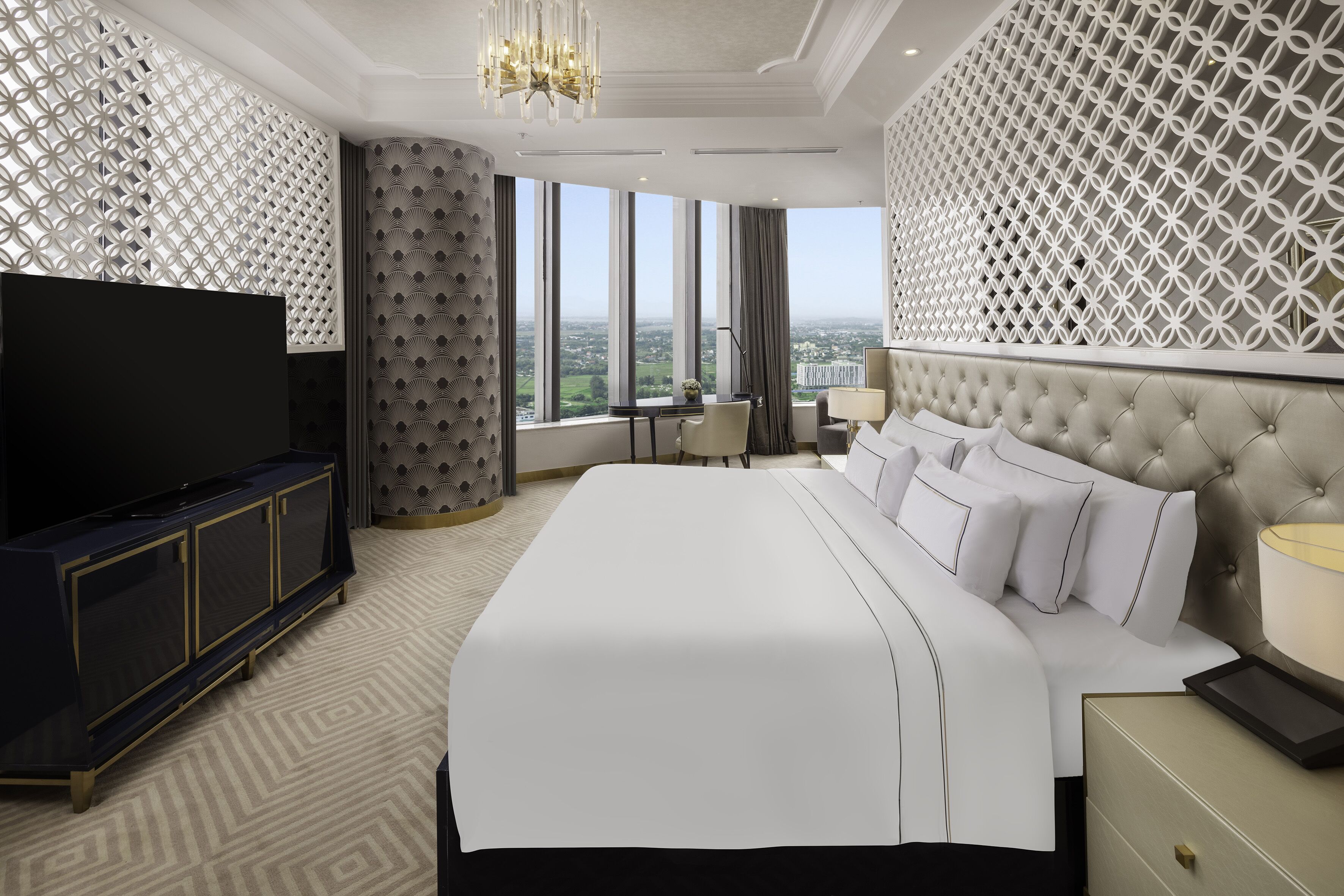 Ein modernes Hotelzimmer mit einem großen Bett, einem Fernseher und Blick auf die Stadt.